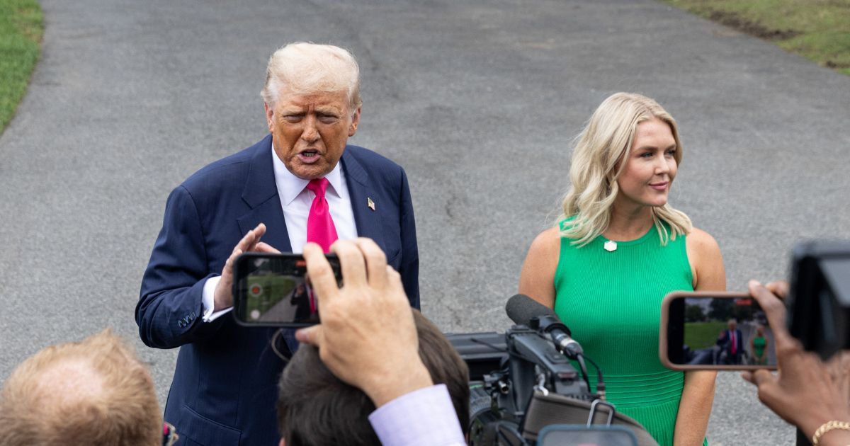 President Donald Trump, accompanied by White House Press Secretary Karoline Leavitt, speaks with members of the media before boarding Marine One on the South Lawn of the White House on July 15, 2025, in Washington, D.C.