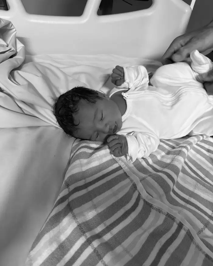 Indy Clinton’s newborn baby laying on a bed